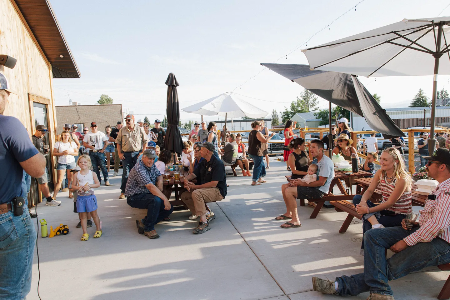 Families and friends gathered at picnic tables on the Tipsy Cow patio