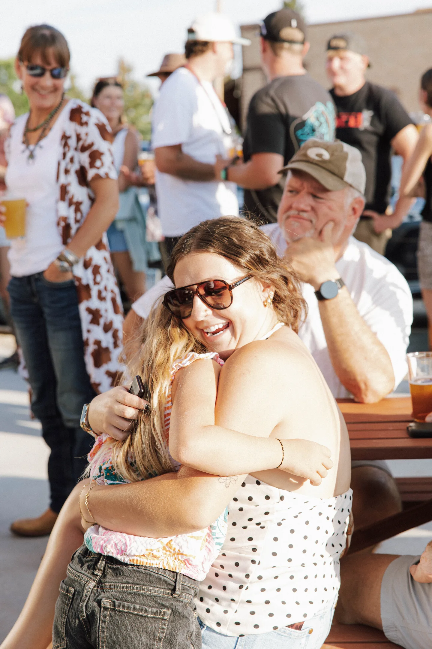 Two guests sharing a hug on the sunny patio